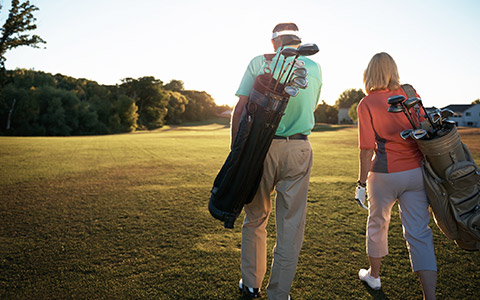 Couple walking with golf bags 